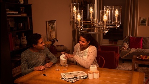 Femme en train de visser une ampoule à la maison