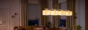 La suspension LED moderne avec plusieurs abat-jours en tissu illumine un salon confortable, présentant des solutions d'éclairage domestique élégantes et économes en énergie pour un confort ambiant en soirée.