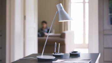 Une lampe de table sur un bureau orienté vers le papier et le stylo