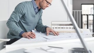 un homme travaillant à la maison à un bureau encombré