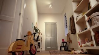 "Entrée lumineuse avec éclairage LED encastré illuminant les étagères, les jouets et un vélo d'équilibre pour enfants. »
