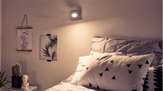 "Chambre élégante avec spot LED gradable créant une ambiance chaleureuse, illuminant une literie géométrique et une décoration minimaliste. »