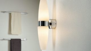 Salle de bain moderne dotée d'une élégante applique murale à LED, illuminant un décor minimaliste et améliorant l'ambiance de type spa.